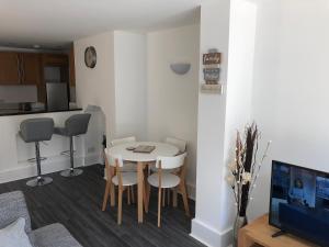 a living room with a table and chairs and a tv at Bournemouth Hot Tub & Sauna Holiday Let in Bournemouth
