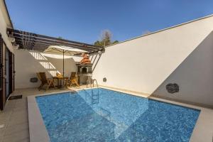 een zwembad met een tafel en een parasol bij Villa Palanga in Trogir