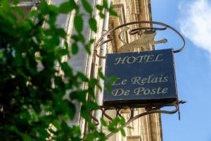 un cartello sul lato di un edificio di Hôtel Le Relais de Poste Arles Centre Historique a Arles