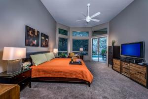 a bedroom with a bed and a flat screen tv at Desert Foothills in Phoenix