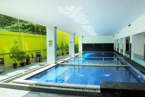 a large swimming pool in a building with yellow walls at Zest Yogyakarta by Swiss-Belhotel International in Yogyakarta