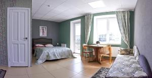 a bedroom with a bed and a table and a window at Apartments on Voykova in Polatsk