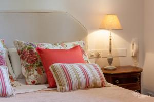 a bed with pillows and a lamp on a table at Es Pou de Biniamar in El Port de la Selva