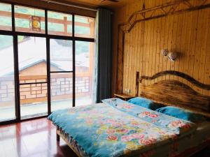 um quarto com uma cama com uma cabeceira em madeira e janelas em Zhangjiajie one step to heaven inn (Yangjiajie ticket office) em Zhangjiajie