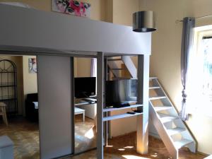 a loft bed with a tv and a desk at Studio Estery in Krakow