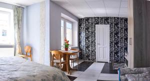 a bedroom with a bed and a table and a door at Apartments on Voykova in Polatsk