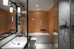 a bathroom with a shower and a sink and a tub at David's Deer Hotel in Chongqing