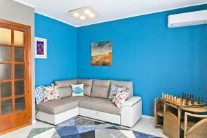 
a living room filled with furniture and a blue wall at Bluemarine Apartment in Gallipoli
