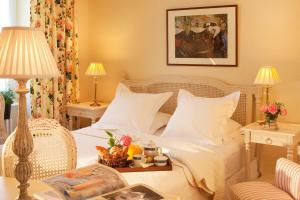 a bedroom with a white bed and two tables with lamps at Gradlon in Quimper