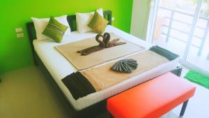 a bedroom with a bed with a green wall at Phangan Guest House in Thong Sala