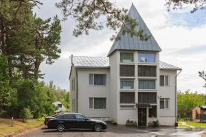 Vallery Guest House في Bigauņciems: منزل فيه سيارة متوقفة أمامه