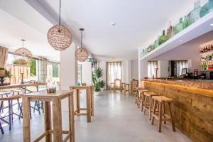 un restaurante con taburetes de madera y un bar en Sa Cala Suites, en Es Caló
