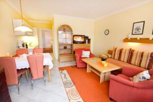 een woonkamer met een tafel, stoelen en een bank bij Gästehaus Jacobs in Bliesdorf