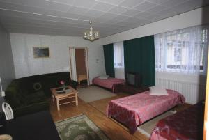 ein Wohnzimmer mit einem Bett und einem Sofa in der Unterkunft Jämsän Gasthaus in Jämsä