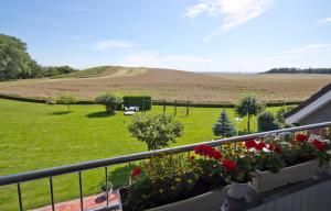een balkon met bloemen en uitzicht op een veld bij Gästehaus Jacobs in Bliesdorf
