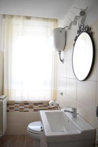 Un baño con lavabo, espejo e inodoro. en B&B CRISPI 53, en Agrigento