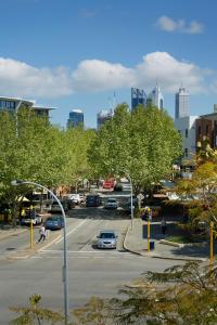 a city street with a parking lot with cars at East Perth Suites Hotel in Perth