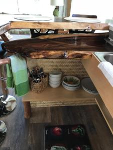 une table en bois avec des assiettes et de la vaisselle sur une étagère dans l'établissement Volcano Eco Cabin & Eco Lodge, à Volcano