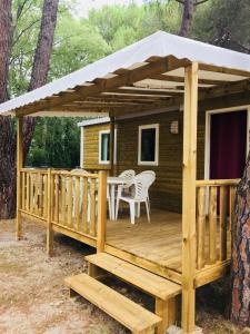 una terraza de madera con mesa y sillas. en Camping Maureillas, en Maureillas