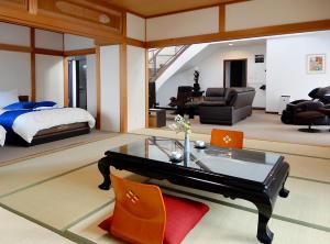 Condominium Panoramique Motomachi في هاكوداته: غرفة نوم بسرير وطاولة وكراسي