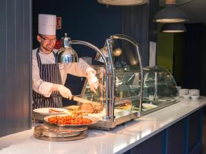 a chef preparing food in a restaurant kitchen at Midlands Park Hotel in Portlaoise