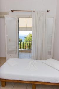 een groot bed in een kamer met een raam bij Soile Georgia in Loutra Edipsou