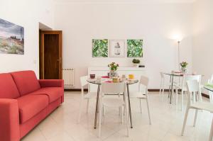 sala de estar con sofá rojo, mesa y sillas en Casa di Nora en Formia