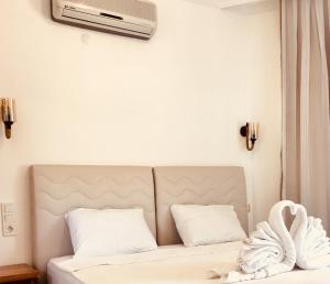 a bedroom with a bed with a air conditioner on the wall at Erol Motel in Orhaniye +81 photos