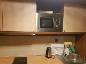 a microwave above a kitchen counter with a sink at Apartmán 401 C - Veľká Lomnica in Veľká Lomnica +15 photos