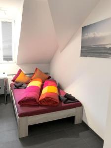 Bett mit bunten Kissen auf einem Zimmer in der Unterkunft HITrental Station Apartments in Luzern