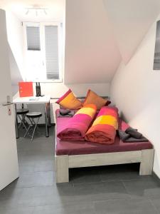 una cama con almohadas coloridas en una habitación en HITrental Station Apartments, en Lucerna