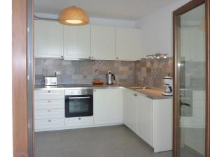 a kitchen with white cabinets and a sink at Villa Mola Kalyva in Mola Kalyva