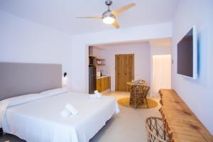 Un dormitorio con una cama blanca y una mesa. en Sa Cala Suites, en Es Caló 35 fotos más