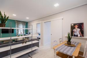 a living room with a dining room table and glass walls at Apartamentos River Santander in Santander