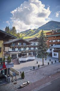 a building with a tree in the middle of a street at Hotel Gamshag in Saalbach Hinterglemm