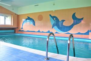 ein Pool mit Delphinen an der Wand in der Unterkunft Pension Kohler in Deštné v Orlických horách