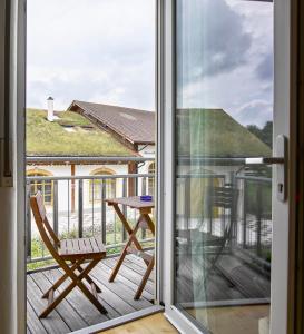 a sliding glass door with a chair and a table on a deck at Hotel Donau-Ries in Mertingen