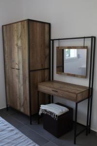 a dressing table with a mirror and a cabinet at Blue4Aqua Apartments in Kavála
