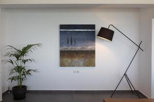 a lamp and a plant in a room with a painting at Blue4Aqua Apartments in Kavála