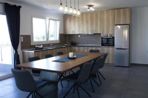 a kitchen with a wooden table with chairs and a refrigerator at Blue4Aqua Apartments in Kavála