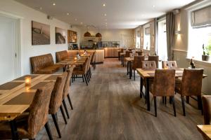 a restaurant with wooden tables and chairs at Hjørring Kro in Hjørring