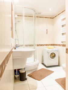 a bathroom with a toilet sink and a washing machine at Apartamenty Osiedle Belweder in Wisła