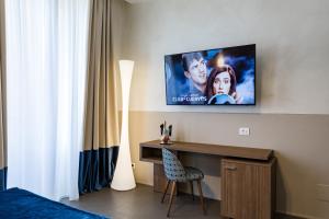 a room with a tv on a wall with a desk at A World Aparts - Barberini Boutique Hotel in Rome