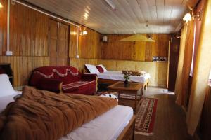 um quarto com duas camas e um sofá e uma cadeira em Vamoose Orchid Villa Homestay em Rinchingpong