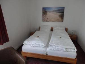 2 Betten in einem Zimmer mit einem Bild an der Wand in der Unterkunft Zur Saale in Weißenfels