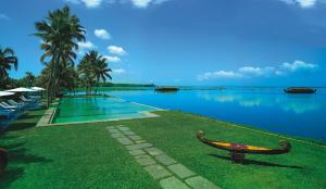 a person sitting on a bench in front of a body of water at Kumarakom Lake Resort in Kumarakom