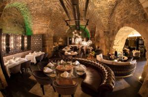 a restaurant with tables and chairs and a brick wall at HSVHN Hotel Hışvahan in Gaziantep