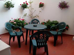 una mesa y sillas en una habitación con flores en Apartamento Castillo, en Granada