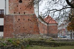 a large brick building with a stone wall at Apartament Pod Aniołami na Starówce w Radomiu in Radom