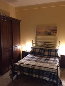 1 dormitorio con 1 cama con manta a cuadros en Agriturismo La Noce, en Bassano Romano